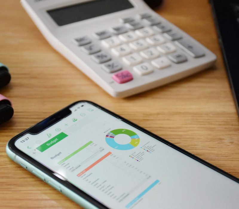 Budgeting on a smart phone with a calculator and pens Budgeting on a smart phone with a calculator and pens
